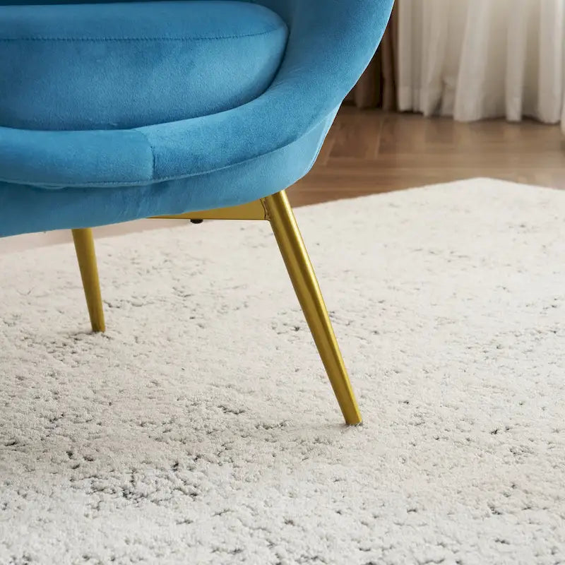 Fauteuil de salon moderne rembourré en peluche avec dossier incurvé et pieds dorés.